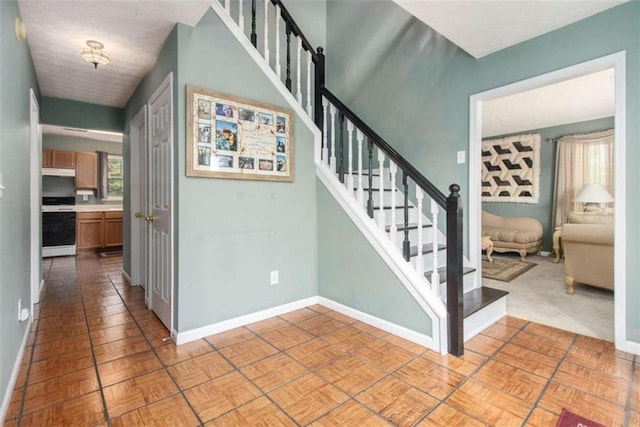 stairs featuring a textured ceiling