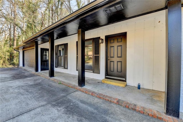 property entrance featuring covered porch and a garage