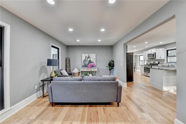 living room featuring sink and light hardwood / wood-style floors