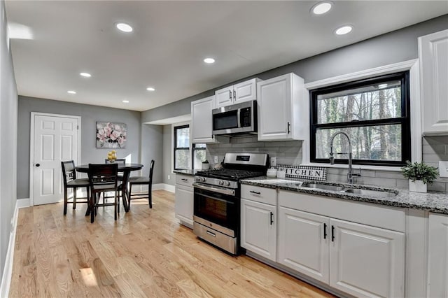 kitchen featuring white cabinets, stone countertops, sink, and appliances with stainless steel finishes