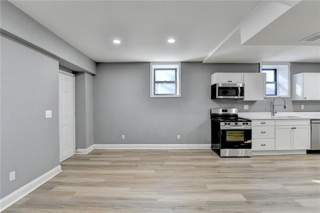 kitchen with a healthy amount of sunlight, white cabinetry, sink, and stainless steel appliances