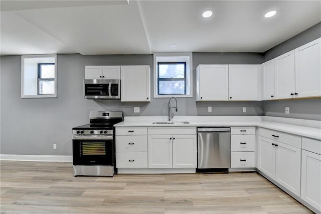 kitchen with a healthy amount of sunlight, white cabinetry, sink, and stainless steel appliances