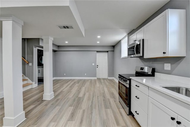 kitchen featuring light hardwood / wood-style flooring, white cabinets, and appliances with stainless steel finishes