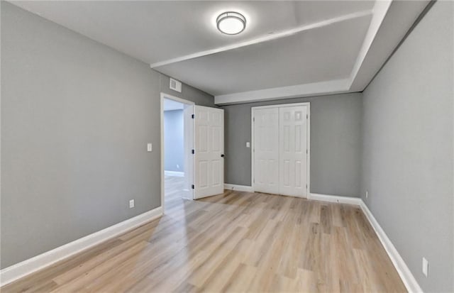 unfurnished bedroom featuring light wood-type flooring and a closet