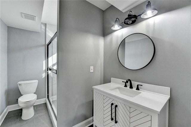 bathroom featuring tile patterned floors, a shower with door, vanity, and toilet