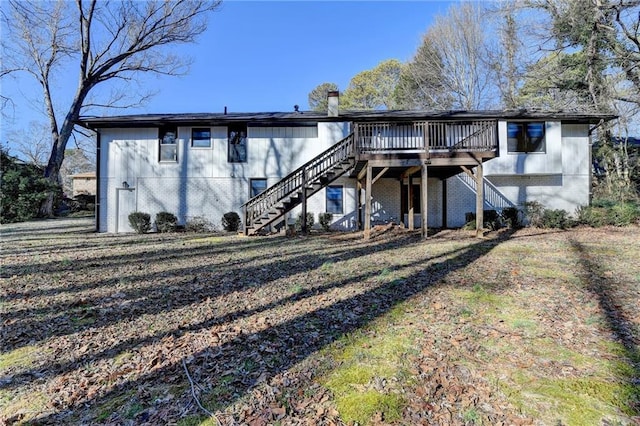 rear view of house featuring a lawn and a wooden deck