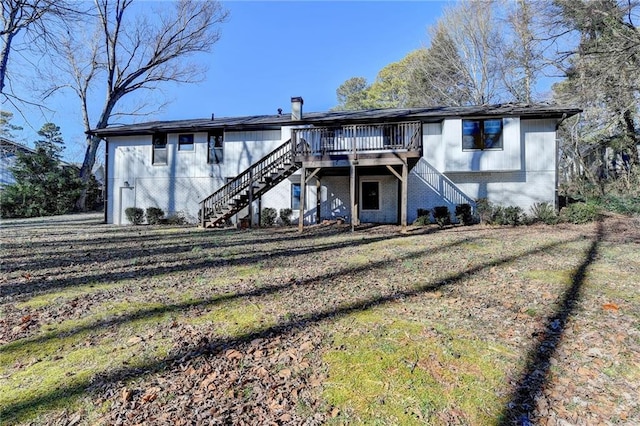 rear view of house with a deck and a lawn