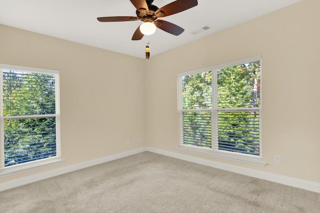 empty room with carpet floors, a healthy amount of sunlight, and ceiling fan