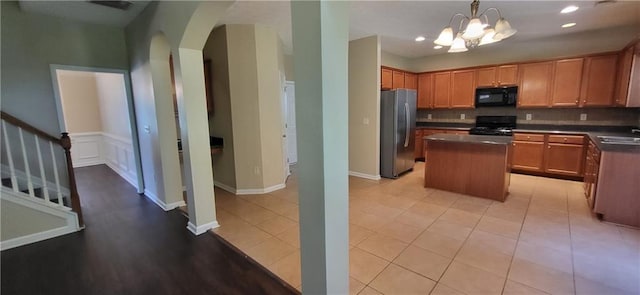 571 Cold Water Ln, Mcdonough, GA 30252 - kitchen with black microwave, freestanding refrigerator, range, arched walkways, and a center island