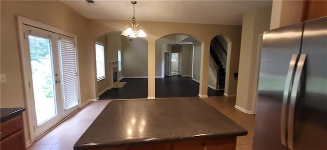 571 Cold Water Ln, Mcdonough, GA 30252 - kitchen featuring freestanding refrigerator, arched walkways, dark countertops, and hanging light fixtures