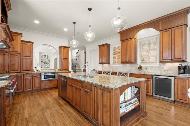 kitchen featuring dishwasher, wine cooler, an island with sink, a sink, and open shelves