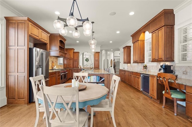 dining space with ornamental molding, a chandelier, recessed lighting, and light wood finished floors