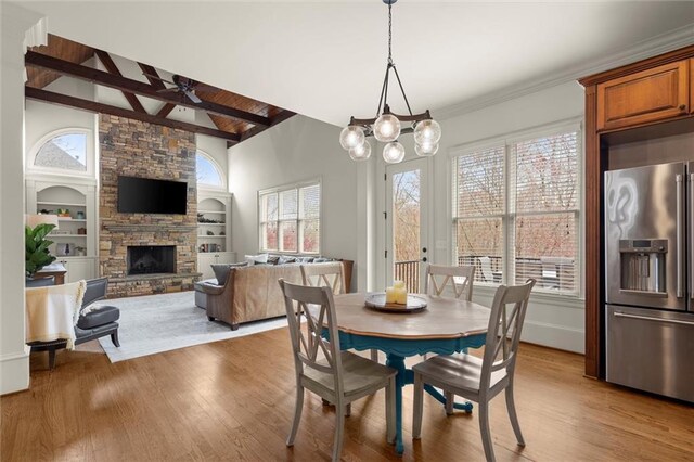 living room featuring wooden ceiling, high vaulted ceiling, beamed ceiling, a stone fireplace, and wood finished floors