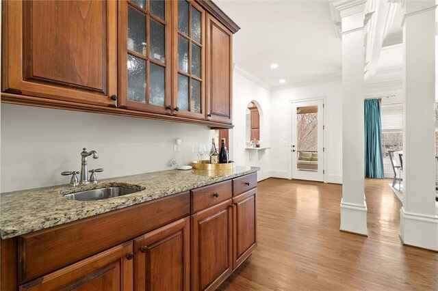 dining room featuring arched walkways, wood finished floors, an inviting chandelier, and crown molding