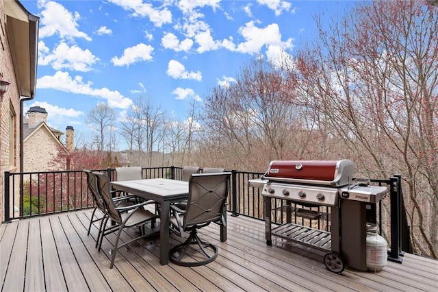 wooden deck with a grill and outdoor dining space
