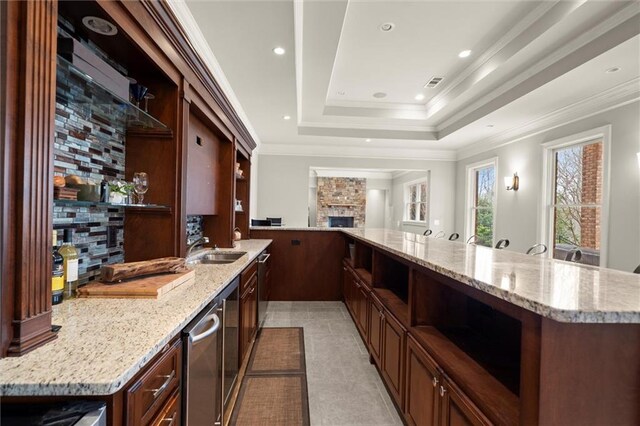 playroom with a tray ceiling, crown molding, arched walkways, and wood-type flooring