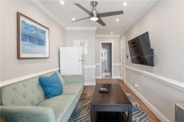 living area featuring baseboards, ornamental molding, wood finished floors, and recessed lighting