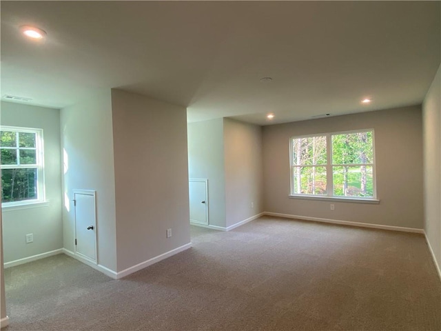 spare room with carpet, healthy amount of natural light, baseboards, and recessed lighting