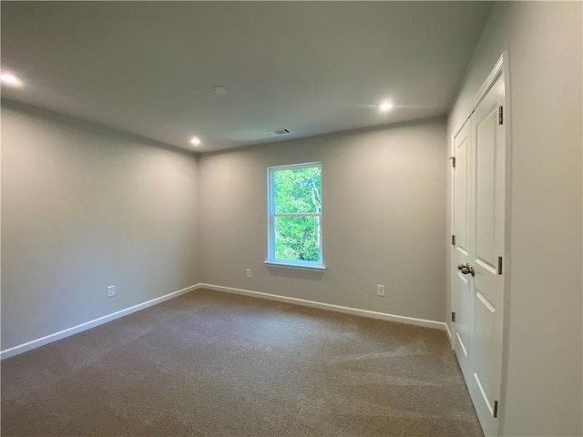 empty room with recessed lighting, baseboards, and dark colored carpet