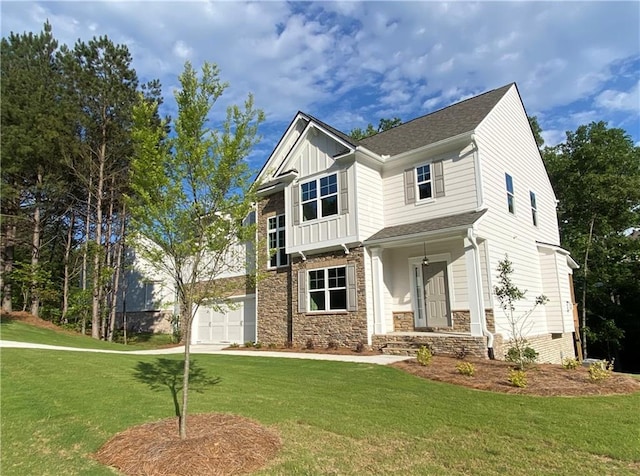 craftsman inspired home with a front yard, stone siding, a garage, board and batten siding, and covered porch