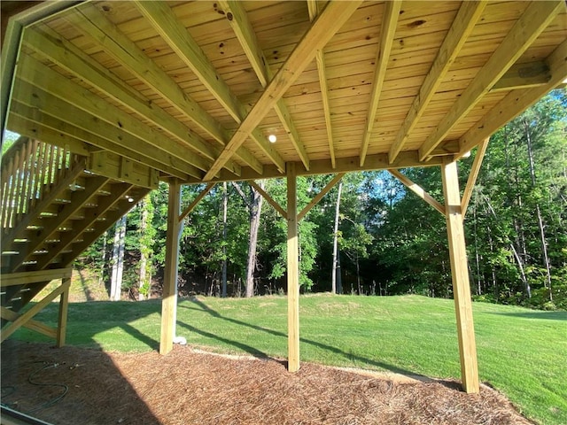 view of grassy yard featuring view of wooded area