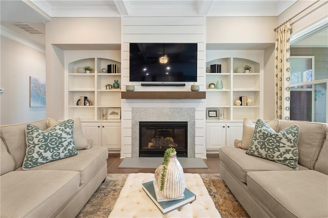 living room featuring a tile fireplace, hardwood / wood-style floors, and crown molding