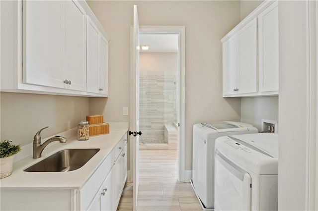 washroom with independent washer and dryer, cabinets, and sink