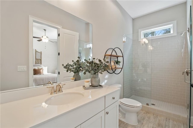 bathroom with vanity, toilet, ceiling fan, and walk in shower