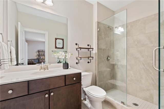 bathroom with walk in shower, vanity, and toilet