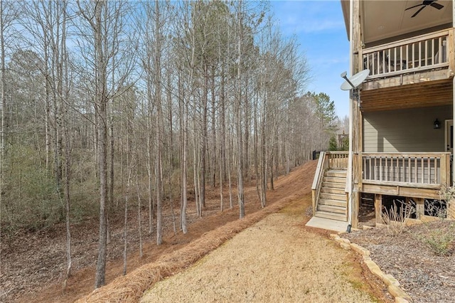 view of yard featuring ceiling fan and a deck