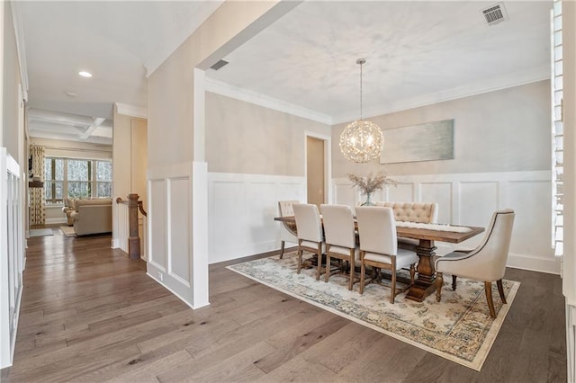 dining room with hardwood / wood-style flooring, coffered ceiling, a notable chandelier, ornamental molding, and beamed ceiling