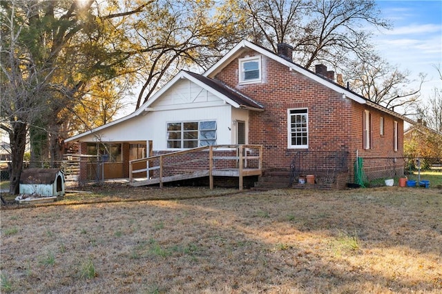 back of property with a wooden deck, a yard, and a storage unit