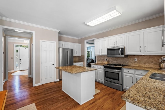 120 Ashewoode Downs Ln, Alpharetta, GA 30005 - kitchen with stainless steel appliances, white cabinets, dark wood finished floors, decorative backsplash, and crown molding