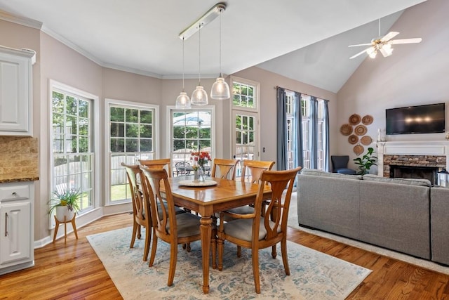 120 Ashewoode Downs Ln, Alpharetta, GA 30005 - dining room featuring plenty of natural light, a fireplace, ceiling fan, light wood-style flooring, and lofted ceiling