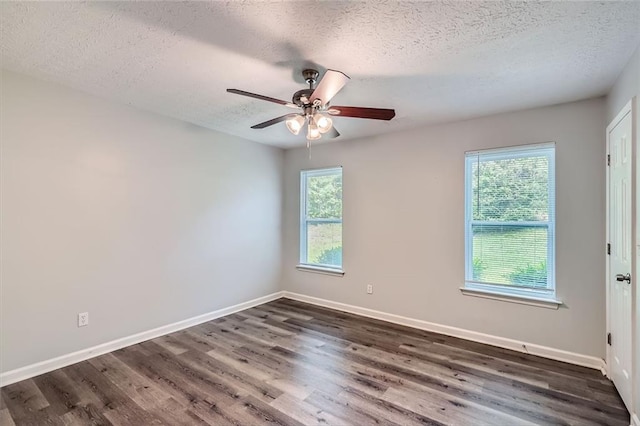 unfurnished room with baseboards, a ceiling fan, dark wood-style floors, and a textured ceiling