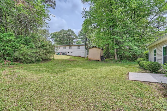 view of yard with an outdoor structure, a storage shed, and a patio
