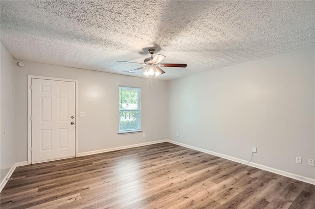 spare room featuring baseboards, a textured ceiling, ceiling fan, and wood finished floors