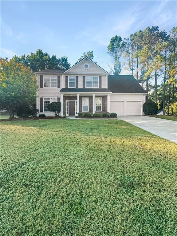 view of front of home with a front yard and a garage