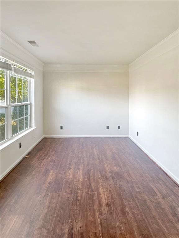 empty room with dark hardwood / wood-style flooring and crown molding