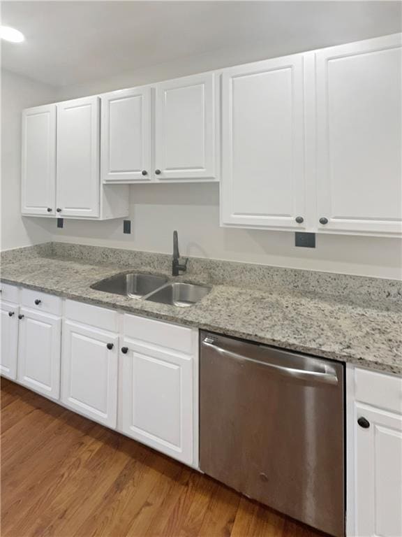 kitchen featuring wood-type flooring, light stone counters, sink, white cabinetry, and stainless steel dishwasher