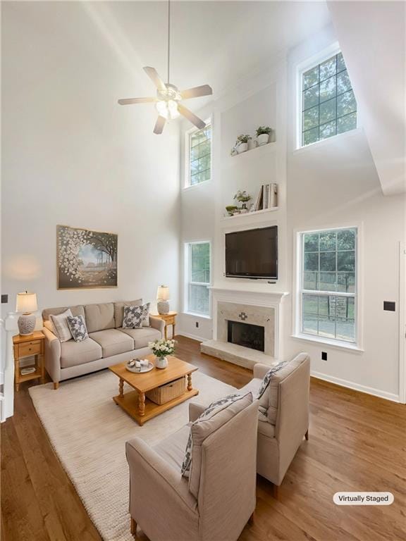 living room featuring hardwood / wood-style flooring, plenty of natural light, and a high ceiling