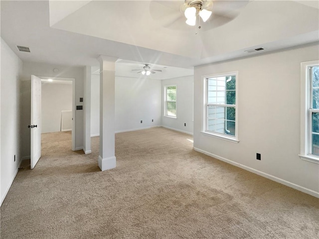 spare room featuring ceiling fan, light colored carpet, and ornate columns