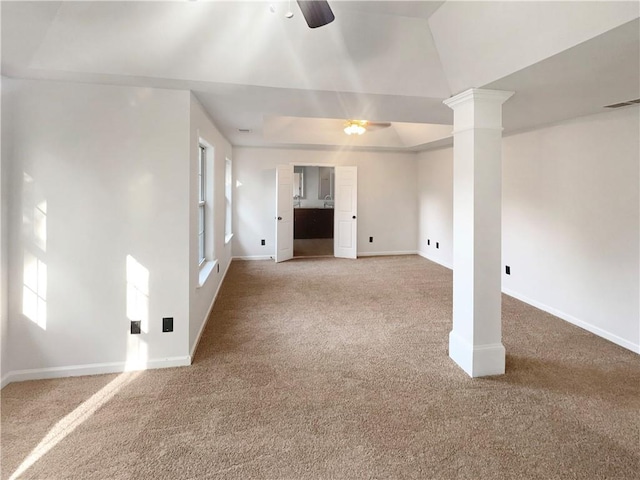 unfurnished living room featuring ceiling fan, light colored carpet, and ornate columns