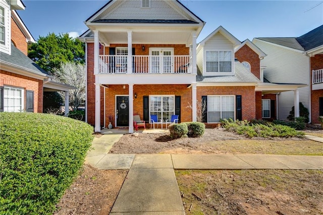 view of front of property featuring brick siding and a balcony