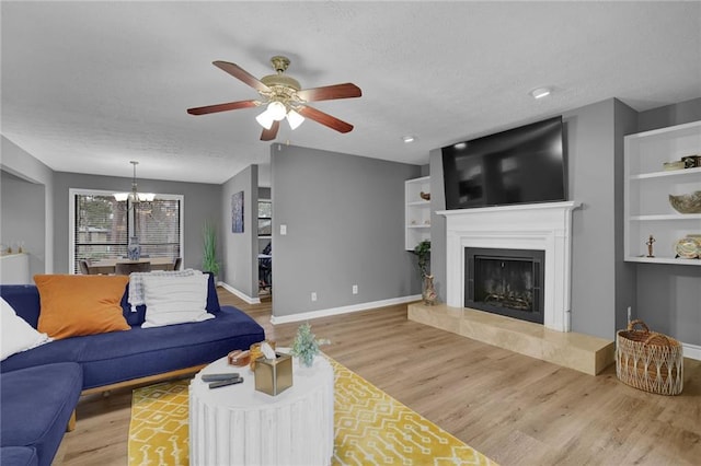 3906 Cedar Cir Unit 3906, Tucker, GA 30084 - living area featuring wood finished floors, ceiling fan, a chandelier, a tiled fireplace, and a textured ceiling