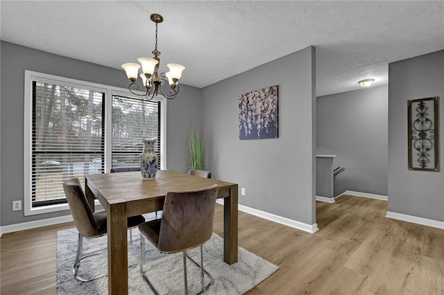 3906 Cedar Cir Unit 3906, Tucker, GA 30084 - dining area featuring a chandelier, a textured ceiling, and light wood-style flooring