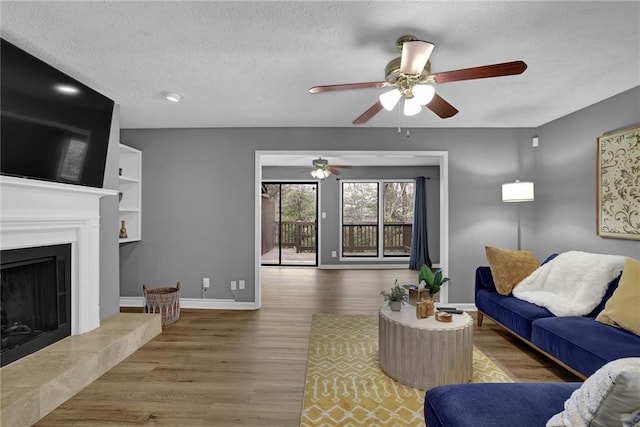 3906 Cedar Cir Unit 3906, Tucker, GA 30084 - living area featuring a ceiling fan, wood finished floors, a textured ceiling, and a tiled fireplace
