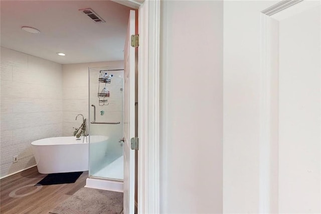 3275 Lenox Rd NE Unit 413, Atlanta, GA 30324 - bathroom with wood finished floors, a freestanding bath, a shower stall, and recessed lighting