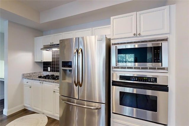 3275 Lenox Rd NE Unit 413, Atlanta, GA 30324 - kitchen featuring appliances with stainless steel finishes, dark wood-style flooring, white cabinets, and decorative backsplash