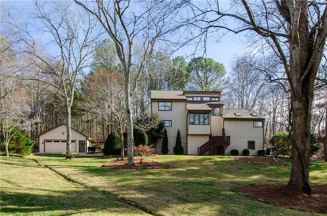 view of front of house with a garage, a front yard, an outdoor structure, and stairway